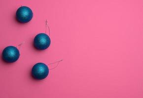 blaue glänzende weihnachtskugeln auf einem rosa hintergrund, festliche kulisse für weihnachten und neujahr foto