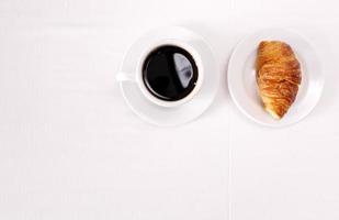 Draufsicht auf einen Kaffee und ein Croissant foto