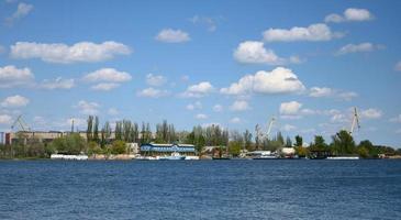 Aussicht von das Fluss Hafen mit Landung Bühne und Kräne auf ein Sommer- Tag. Cherson Ukraine foto