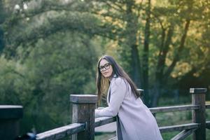 schön Mädchen im Mantel suchen beim Kamera foto