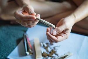 Frauen Cannabis halten ein rollen Joint von Marihuana im das Zimmer , Drogen Betäubungsmittel Konzept. legal Marihuana. foto