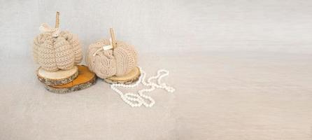 Hobby-Hintergrund mit handgefertigten Strickkürbissen und weißen Perlen. DIY, Basteldekoration für Herbst- und Winterferien. foto