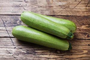 frische rohe Zucchini essfertig auf Holzhintergrund mit Kopierraum. foto