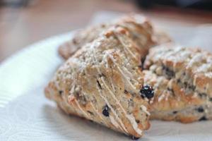 Scones mit blauen Beeren, serviert auf weißen Tellern foto