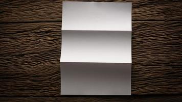 weißes leeres gefaltetes Papier auf Holztisch foto