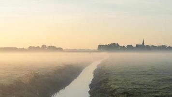 Sonnenaufgang mit Nebel über den Feldern von 't Woudt, Niederlande. foto