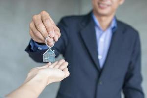 Hausmakler und Immobilien nehmen Schlüssel zu den Eigentümern foto