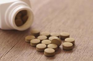 braune Medizin in der Pille auf Holzhintergrund