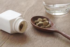 Kräutermedizin in Pille auf Holztisch foto