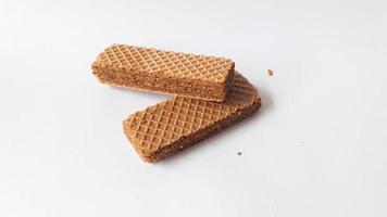 Leckere Wafer-Sticks auf weißem Hintergrund, flach gelegt. Süßes Essen foto