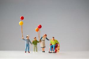 Miniaturfiguren einer Familie mit Luftballons foto