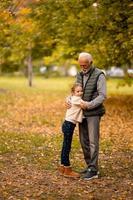 Großvater verbringt am Herbsttag Zeit mit seiner Enkelin im Park foto