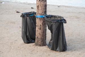 schwarze Müllsäcke am Strand foto