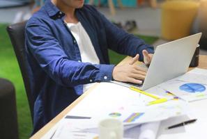 Person, die von zu Hause auf Laptop arbeitet foto