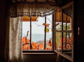 idyllischer Blick durch ein Fenster einer Hütte im Herbst foto