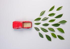 Automodell und Blätter auf weißem Hintergrund foto