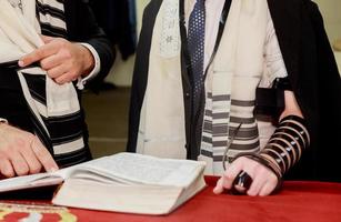 Hand eines Jungen, der die jüdische Thora in der Bar Mizwa liest foto