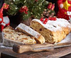 Stollen ein traditionell europäisch Kuchen mit Nüsse und kandiert Frucht, ist abgestaubt mit Glasur Zucker foto