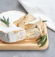 runder Brie-Käse auf einem Holzbrett foto