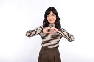 jung asiatisch Frau Hände Herstellung ein Herz gestalten auf ein Weiß isoliert Hintergrund foto