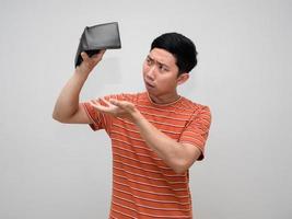asiatisch Mann Orange gestreift fühlt sich traurig mit Nein Geld im Brieftasche isoliert, arm Mann unzufrieden Über nicht genug Geld foto
