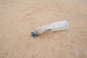 Plastik Flaschen von Getränke auf das Strand Sand foto