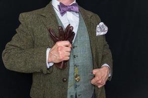 Porträt von Gentleman im Tweed passen auf schwarz Hintergrund halten Leder Handschuhe. Jahrgang Stil und retro Mode. klassisch Englisch Gentleman. foto