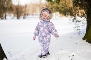 Baby Mädchen tragen Kind Schneeanzug auf ein sonnig eisig Winter Tag. foto