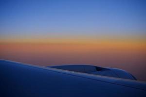 Nahaufnahme des Flugzeugflügels mit schönem Skyline-Hintergrund. foto