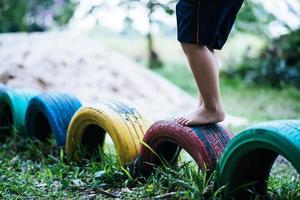 Kind läuft auf Reifen auf dem Spielplatz foto