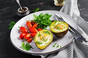 Avocado gebacken mit Ei und frisch Salat. Vegetarier Gericht. ketogen Diät. Keto Essen foto