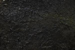 schwarz Stein Mauer im das Höhle Hintergrund. foto