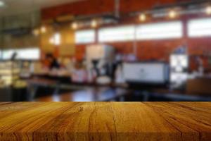 hölzern Tabelle mit verschwommen Kaffee Geschäft Hintergrund, geeignet zum Essen und Getränk Konzept. foto