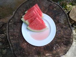 Sommer- reif geschnitten Wassermelone. saftig Scheibe von reif Wassermelone, schließen hoch. Konzept Sommer- reif Beere auf ein hölzern Tafel. foto