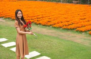 asiatisch Frau lächelnd glücklich unter schön Blumen foto