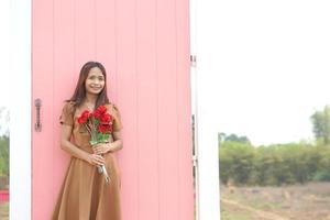 asiatisch Frau lächelnd glücklich unter schön Blumen foto