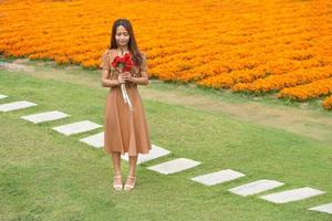 asiatisch Frau lächelnd glücklich unter schön Blumen foto