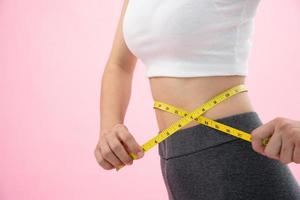 Ernährung und Diät. Schönheit schlanker weiblicher Körper mit Maßband. frau in trainingskleidung erreicht gewichtsverlustziel für ein gesundes leben, verrückt nach dünnheit, dünner taille, ernährungsberaterin. foto