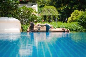 Schöne südostasiatische Frau im entspannenden Pool. foto