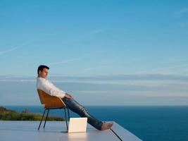 Entspannter junger Mann zu Hause auf dem Balkon foto