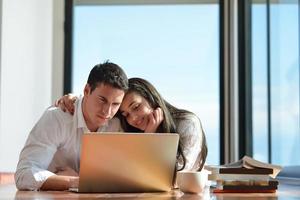 entspanntes junges paar, das zu hause am laptop arbeitet foto