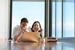 entspanntes junges paar, das zu hause am laptop arbeitet foto