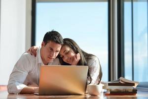 entspanntes junges paar, das zu hause am laptop arbeitet foto