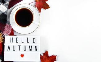 Hallo Herbstkonzept. Tasse heißen Espressokaffee und gefallene rote Blätter auf weißem Hintergrund. warmes Plaid und Getränk für kaltes Wetter. foto
