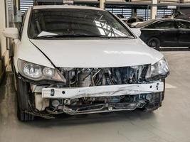 Beschädigtes Auto wartet auf Reparatur in der Autowerkstatt foto