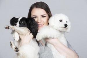 ein süß jung Frau ist halten ihr Papillon und Bichon Welpe. Liebe zwischen Inhaber und Hund. das Mädchen Theaterstücke mit das Hunde. Haustiere. foto