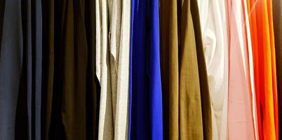 bunt Muster von Kleidung, Baumwolle, Vorhang oder Stoff hängend im Linie beim Mode Geschäft zum Hintergrund foto