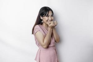 ein Porträt von ein süß asiatisch Frau gekleidet im Rosa, und Gefühl aufgeregt und isoliert durch ein Weiß Hintergrund foto