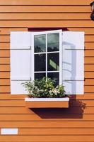 Weiß Fenster öffnen und Blume beim Haus foto