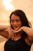 Porträt Bild von ein asiatisch Frau mit schwarz Haar tun ein sehr schön sexy Pose auf das Strand foto
